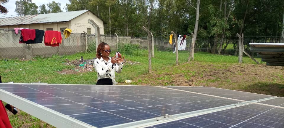 Catherine Kyalo takes a photo of the Solar Panel at St John Paul II College